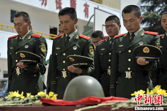 4月3日,武警云南总队第二支队武警官兵在一个被子弹穿透的钢盔前,举行