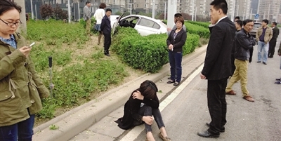 轿车掉了右前轮,撞倒路灯又冲上了绿化带。
