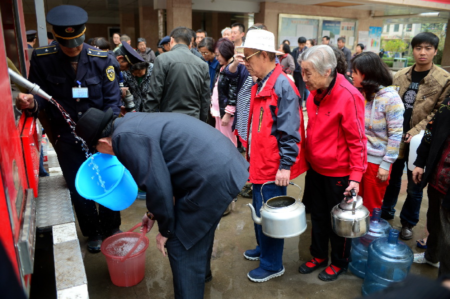 4月12日,在兰州市区一居民小区内,居民正在排队接水.