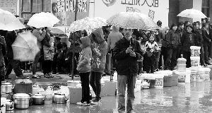 昨日，甘肃省兰州市西固区一居民区内，领水的居民在政府提供的免费饮用水发放点前排起长长的队伍。早报见习记者 丁毅 图