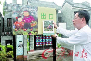 胡锦雄展示自己的画作,园区所用画作确实与其原作一模一样。