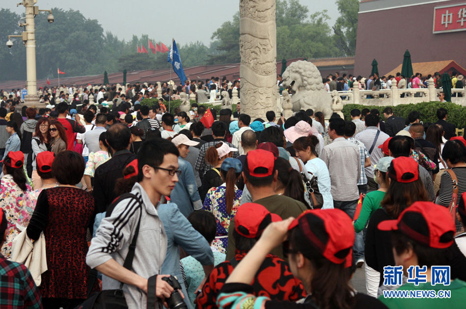 5月1日，北京，东长安街两侧的人们排队进入广场。小长假首日，天安门广场及故宫涌入大批游客。