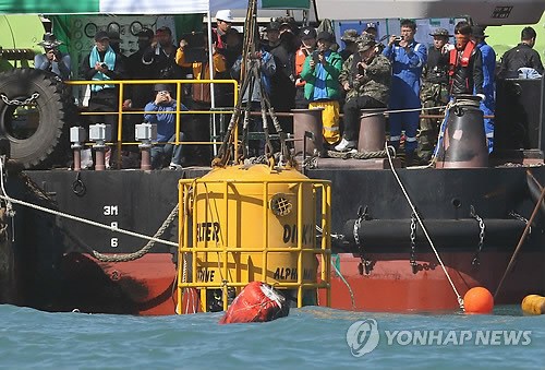 强开舱门 开展第二轮搜救(图 资料图片:救济队正在向海里下放潜水钟
