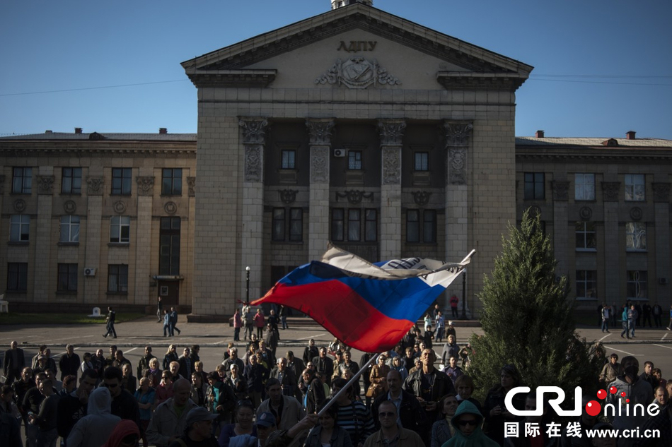 当地时间2014年5月7日,在乌克兰卢甘斯克亲俄份子拿着俄罗斯国旗站在
