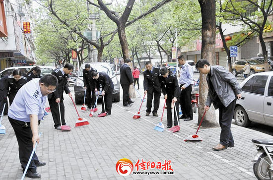 近日,河南信阳市行政执法支队在胜利南路开展卫生大扫除。