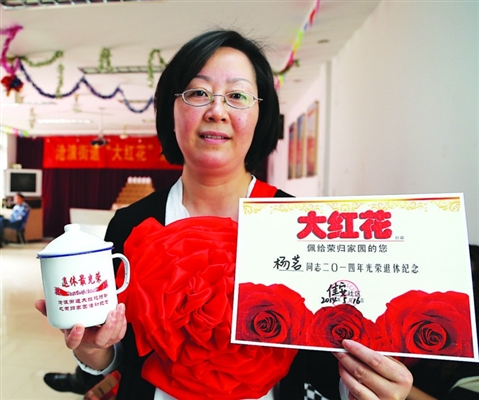 三社区为新退休居民戴大红花(图)