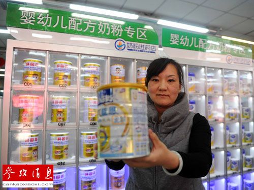 资料图：2013年10月26日，一名消费者在北京永安堂大药房展示刚刚购买的奶粉。新华社记者 公磊 摄