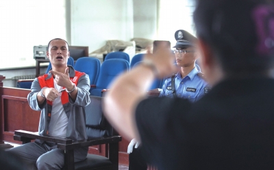 张志国在法庭上用手语回答提问。京华时报记者蒲东峰摄/视频