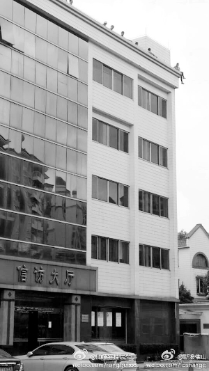 女子在楼顶暴晒了5个小时后,在众人劝说下才答应下来。 信息时报记者 董有逸 摄