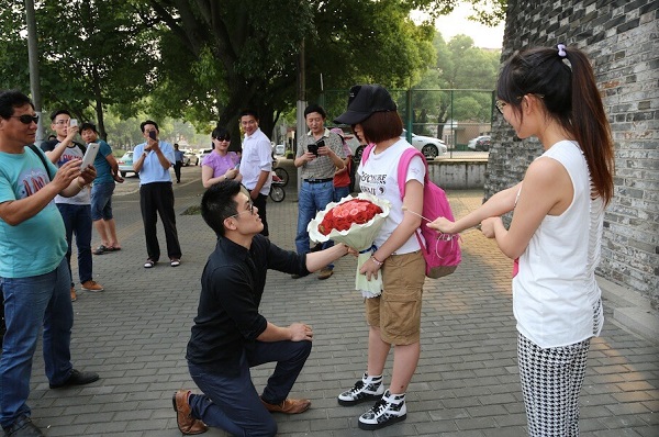 图说:男子下跪求婚,拿花女生为"萌萌".网络图