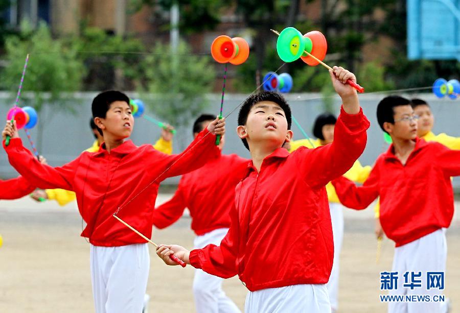 6月11日,秦皇岛市山海关区南园小学空竹表演队成员在练习抖空竹.