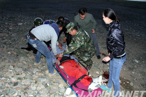 图为:边防警官与卫生院人员救治受伤群众