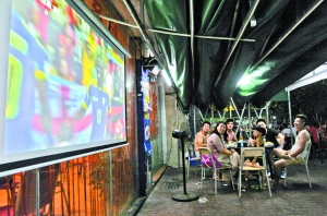 世界杯开幕后,大排档架起大屏幕直播球赛,吸引食客。 记者罗知锋摄