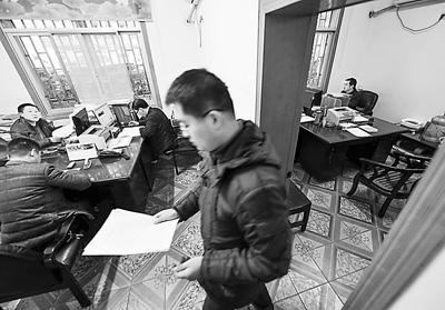 新邵县发改局下属的五个股的10名工作人员在两间打通的办公室内办公 新华社记者 白 禹摄