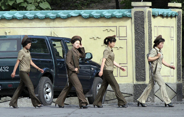 原文配图：朝鲜女兵着军装背步枪巡视。