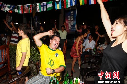 6月29日凌晨，当智利队最后一个点球打在门柱上后，北京巴西之家的球迷纷纷举起双手，为巴西队晋级世界杯八强庆祝。　张浩　摄