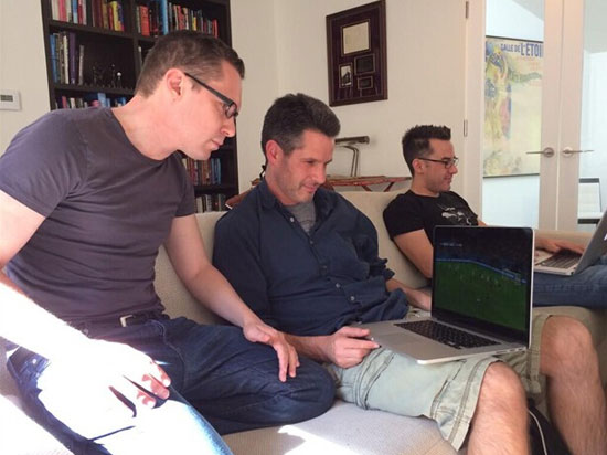 布莱恩用笔记本看世界杯，他旁边的是编剧西蒙-金伯格（《X战警：逆转未来）、迈克尔-道赫蒂（《超人归来）