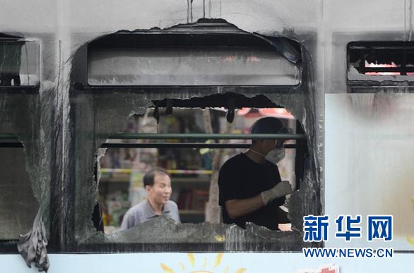7月5日，工作人员在发生燃烧后的公交车内查看现场。 新华社记者 韩传号