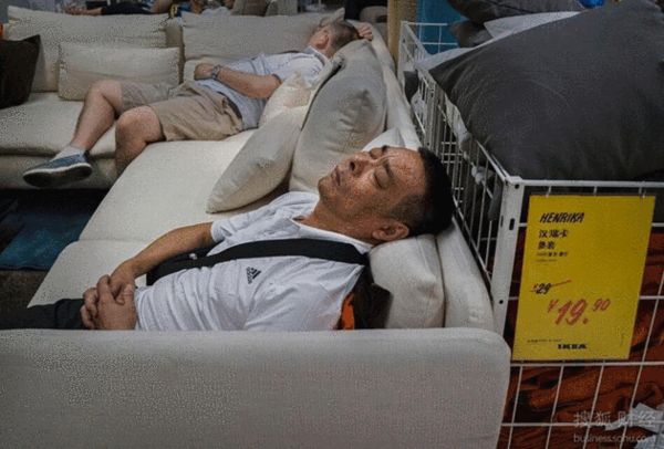 图为顾客在宜家商场陈列的沙发或床上睡觉休息.