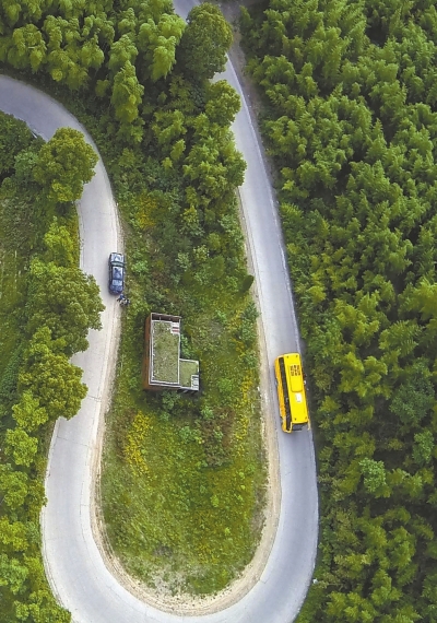 一辆校车行驶在德清县莫干山镇的盘山公路上(5月22日摄).