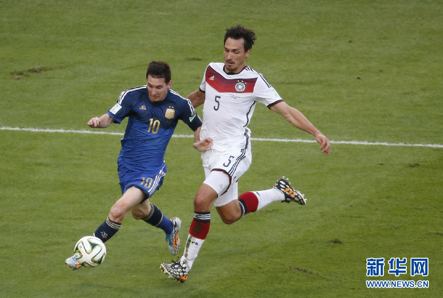 7月13日，阿根廷队球员梅西（左）在比赛中突破德国队胡梅尔斯。当日，在巴西里约热内卢马拉卡纳大球场进行的2014年巴西世界杯决赛中，德国队对阵阿根廷队。 新华社记者廖宇杰摄