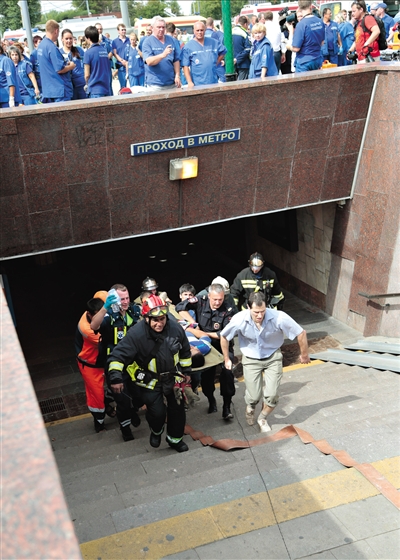7月15日，救援人员将受伤的乘客抬出地铁站。