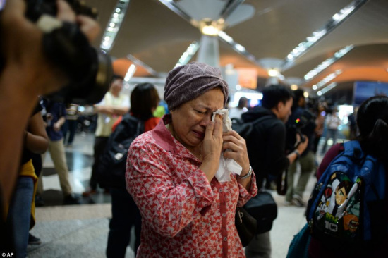 图为一名马航MH17失事客机遇难者的家属在哭泣。