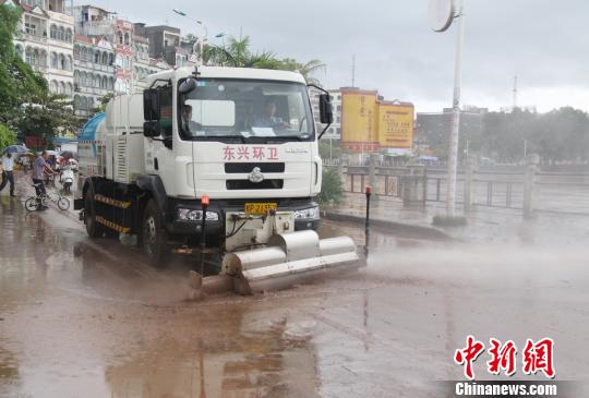 环卫部门使用洒水车清洗河堤路上的淤泥 陈义才 摄