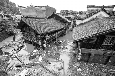 7月16日，凤凰古城内街道被水淹没，漂浮着杂物。新华社发