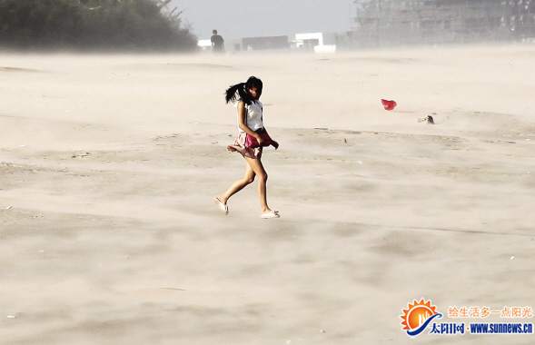昨日受台风“麦德姆”影响，厦门沙滩上的沙子被大风刮起，行人如同走在沙漠里。记者 陈理杰 摄