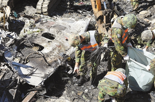 7月25日,搜救人员在坠毁飞机残骸中在做最后观察和清理.
