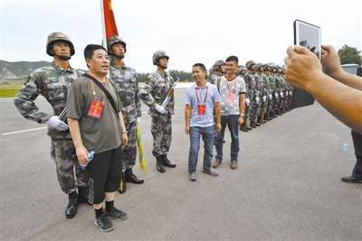 在北京卫戍区警卫三师某部参观的劳模们纷纷与威武的仪仗兵合影留念.