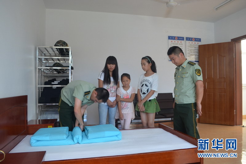留守儿童观看边防民警叠被子