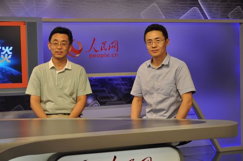 图为人民日报社高级记者白剑峰(右)