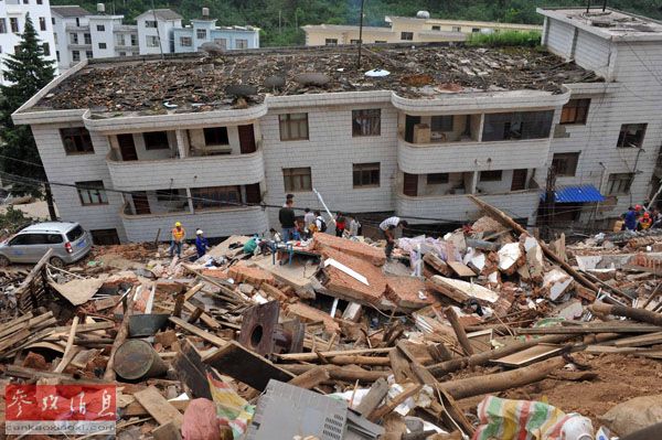 8月4日，龙头山镇居民在清理废墟，寻找失踪者。