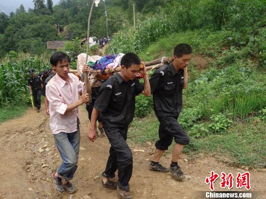 图为民警冒雨徒步奔赴包谷垴乡红石岩村。 唐远均 摄