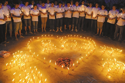 8月8日,在云南鲁甸县龙头山镇骡马口,人们点燃蜡烛,悼念逝者.