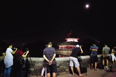 昨晚，摄影爱好者在故宫角楼下拍月亮。新京报记者 高玮 摄