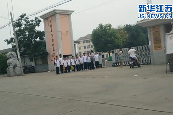视频截图显示，一名男性工作人员正在抬脚准备踹学生。