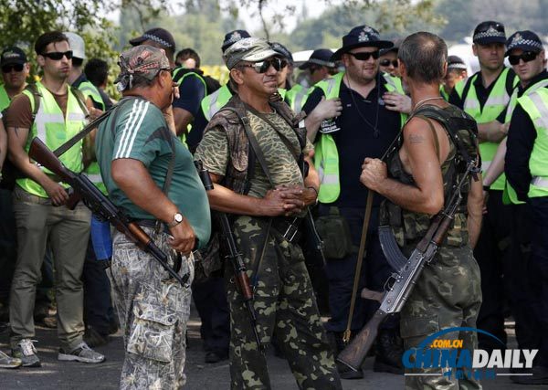 2014年8月4日，在乌克兰东部顿涅茨克州马航客机坠毁地点附近，来自荷兰和澳大利亚的专家准备展开工作，他们前面站着一些民间武装人员。（图片来源：路透社）