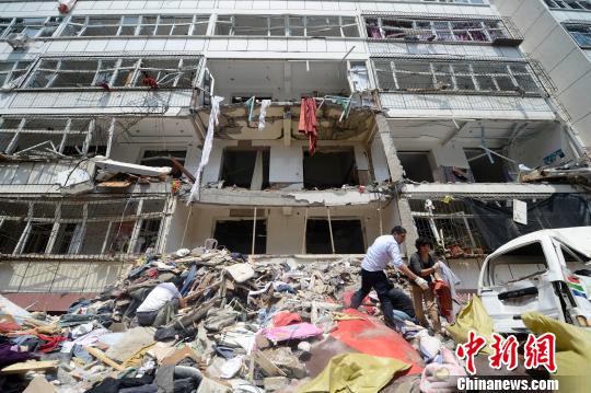 在发生爆炸居民楼南侧，多位市民正在清理财物。 韦亮 摄