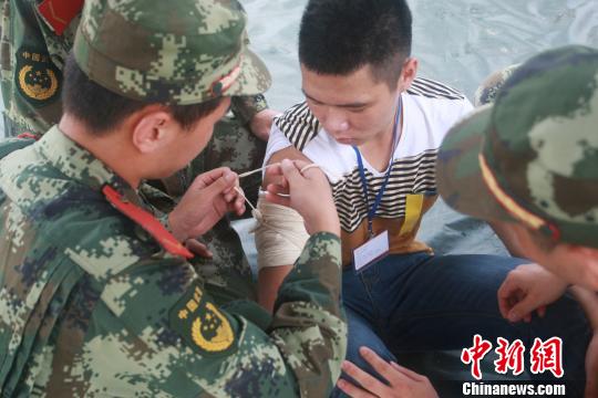 图为演习中官兵为受伤群众包扎伤口 王玉龙 摄