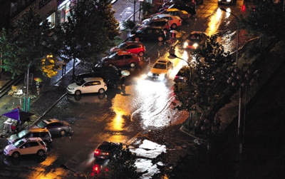 昨晚，突降暴雨，一小区的车辆在积水中行驶。拍者 风云