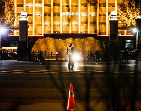夜幕下的山西省委大楼前,一名警察在门口执勤,而一个红色的警示标志则放在路边。 周平浪 澎湃资料