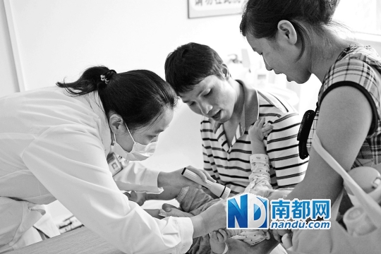 市妇幼保健院,一名儿科医生正在为小宝贝做检查.