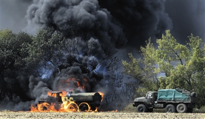 4日，乌克兰东部，一辆“身份不明”的军车被炮火击中燃烧。在乌东部局势恶化之际，乌政府军与民间武装一天之内便谈判决定停火。