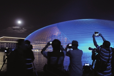 北京皓月当空,夜色醉人。京城的市民与摄影爱好者在国家大剧院拍摄中秋明月。图/CFP