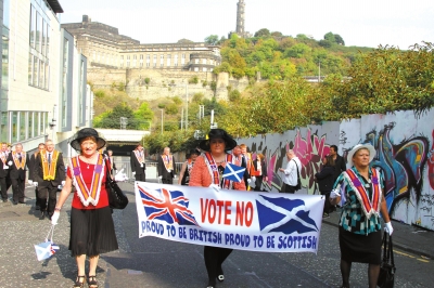 9月13日,人们在苏格兰首府爱丁堡参加反对苏格兰独立万人大游行。图为三名游行者手持标语上写着“请投反对票，做骄傲的英国人，做骄傲的苏格兰人”。新华社发