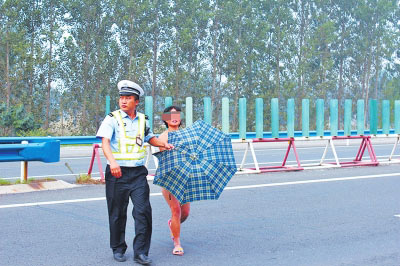 裸奔女在民警守护下离开高速路