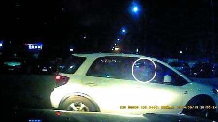 从网友行车记录仪拍下的视频可以隐约看到，驾驶座上的大人抱着个娃娃。 视频截图